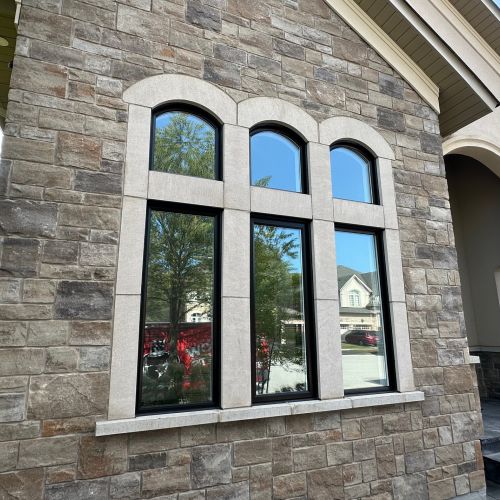Stone wall with modern black-framed windows